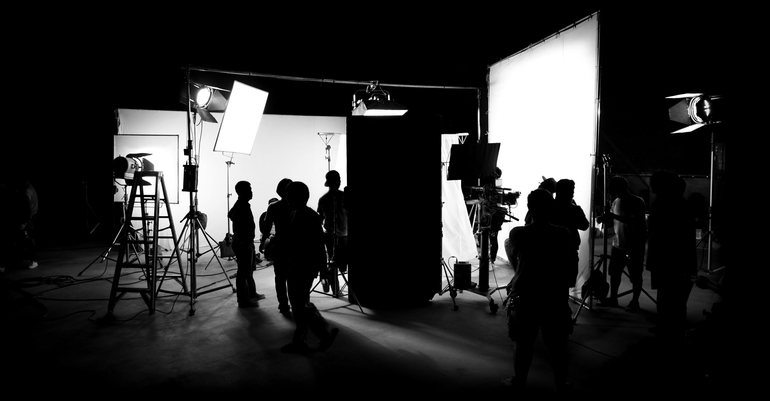 Silhouette,Images,Of,Video,Production,Behind,The,Scenes,Or,B-roll Silhouette images of video production behind the scenes or b-roll or making of TV commercial movie that film crew team lightman and cameraman working together with director in big studio